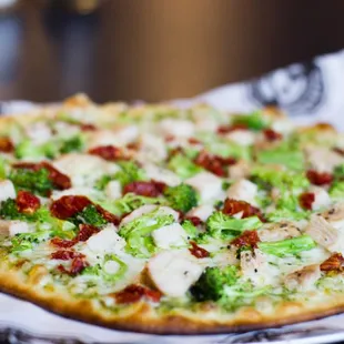 a pizza with broccoli and chicken