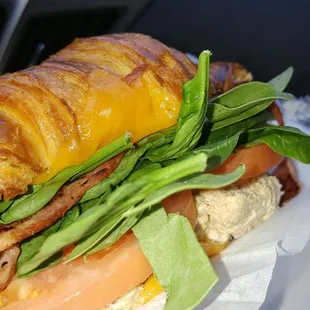 a croissant sandwich with lettuce and tomato