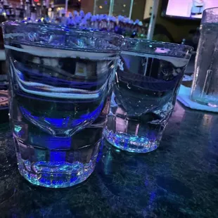 two glasses of water on a bar counter