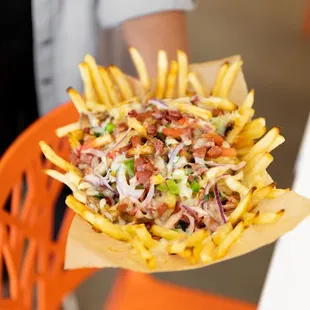 a person holding a basket of french fries