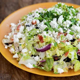 a plate of salad on a wooden table