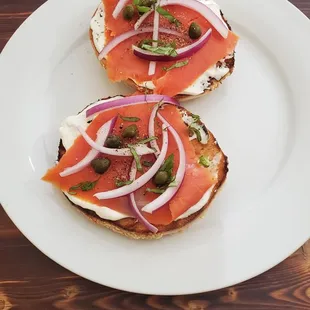 two slices of bread topped with smoked salmon and onions