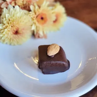 a piece of chocolate with almond on top