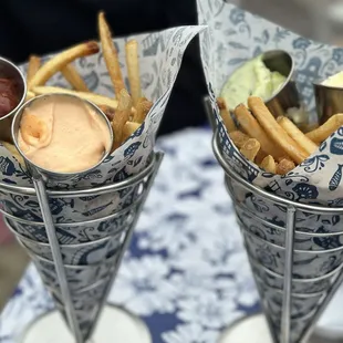 two cones with fries and condiments