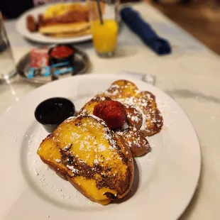 Three thick slices of challah bread dipped in crème brûlée batter, griddled &amp; topped with powdered sugar