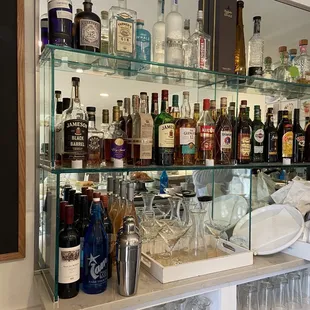 a shelf of liquor bottles and glasses