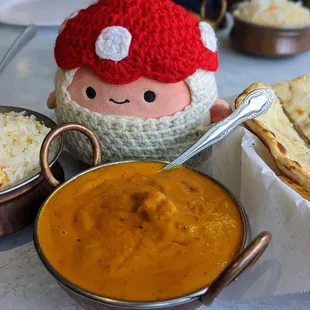 a bowl of curry, a bowl of rice, and a stuffed doll