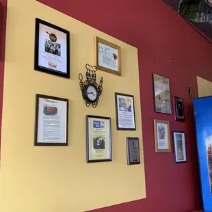 a red wall with a clock and a pepsi sign
