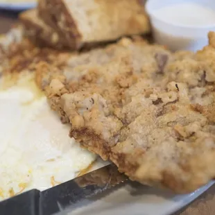 Chicken fried steak with over-easy eggs, hash browns, and toast