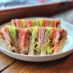 Club Combo has ham, turkey, cheddar cheese, bacon, lettuce, and tomato with Thousand Island sauce.