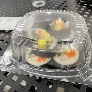 sushi in plastic containers on a table