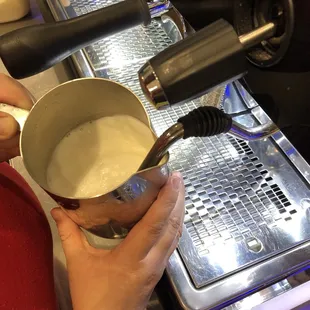 a person pouring milk into a bowl