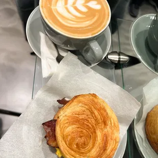 a croissant sandwich and a cup of coffee