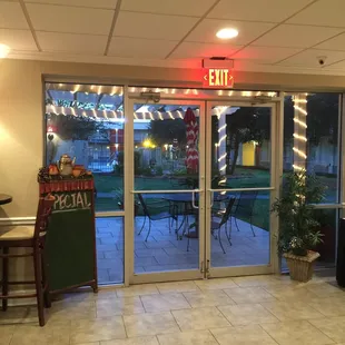 View of the pool area from inside the restaurant. There are three tables on the patio when the weather is nice.