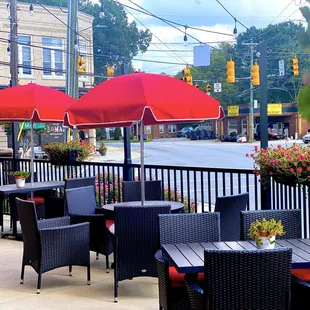 tables and chairs with red umbrellas