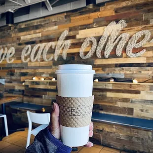 a person holding a cup of coffee