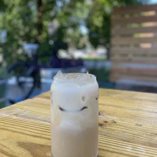 a glass of iced coffee on a wooden table