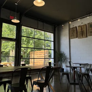tables and chairs in front of large windows