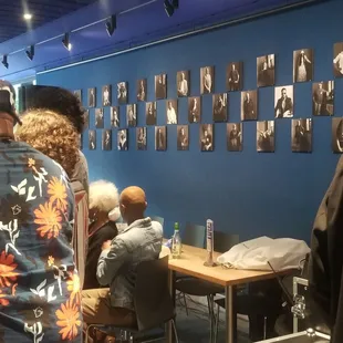 people sitting at tables and looking at pictures on the wall