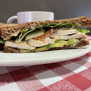 a sandwich on a plate with a cup of coffee