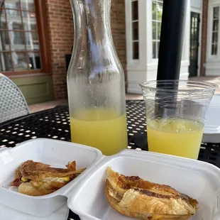 Carafe of mimosa and bacon, egg cheese crossiant