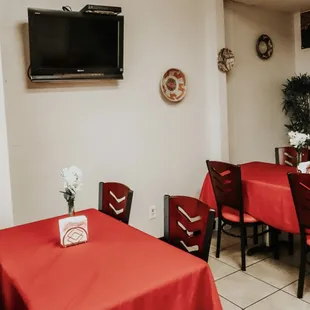 tables and chairs with red tablecloths