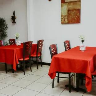 tables and chairs with red tablecloths