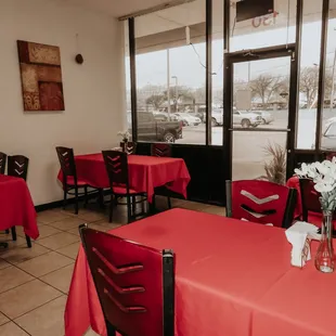 tables and chairs with red tablecloths