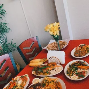a red table with plates of food on it