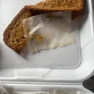a sandwich and pickle in a styrofoam container