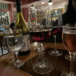 a table with wine glasses and bottles of wine
