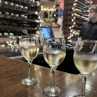 three glasses of wine on a bar