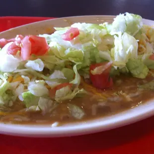 Smothered Chicken Burrito with Pork Green Chile, Cheese, Lettuce and Tomato.