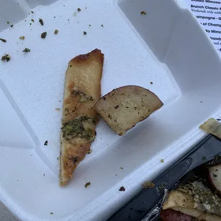 a slice of pizza left in a styrofoam container