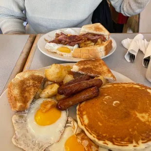 a breakfast of pancakes, eggs, sausage and toast