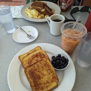 a plate of french toast, blueberries, and orange juice