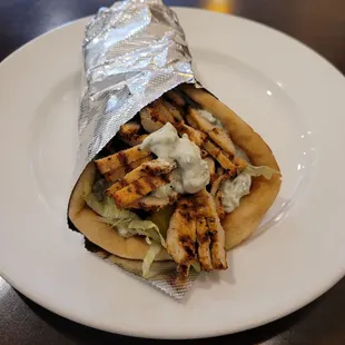 a plate with a sandwich wrapped in foil