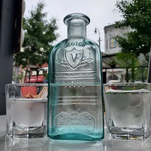 a blue bottle and two glasses