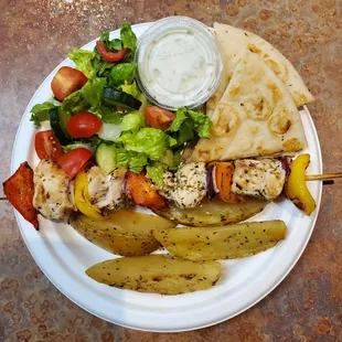 chicken skewers and vegetables on a plate
