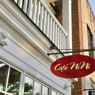 a red sign hanging from the side of a building