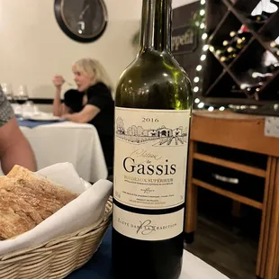 a bottle of wine and a basket of bread