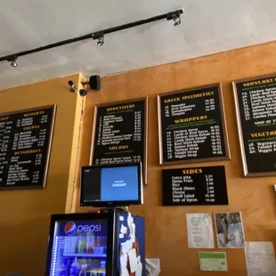 menus on the wall above a vending machine