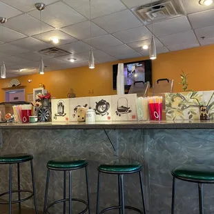 a bar with stools and a television