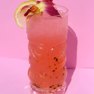 a pink cocktail with a purple flower