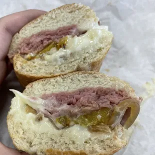 a hand holding a half eaten sandwich