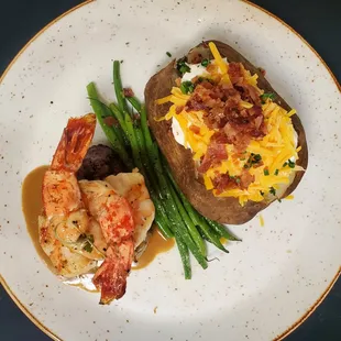a plate of food with shrimp, potatoes, and asparagus