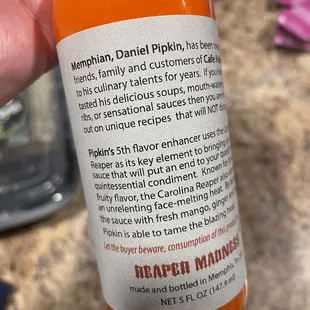 a hand holding a bottle of orange juice