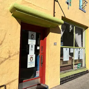 a yellow building with a red door