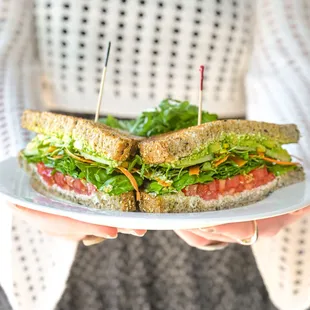 a person holding a sandwich