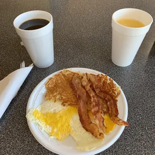 a breakfast of eggs, bacon and hash browns